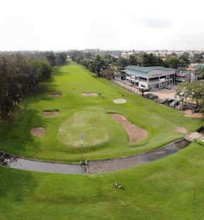 Aerial view of a green and bunkers beside the clubhouse
